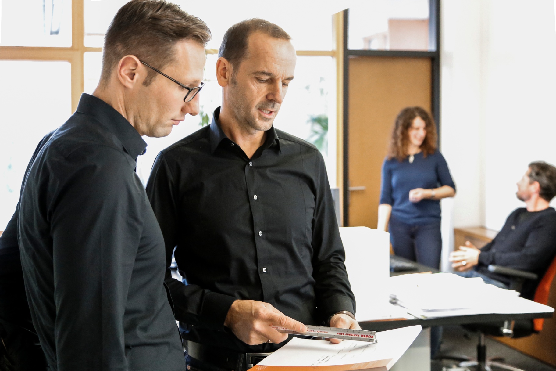 Casa-Nova-Team am Schreibtisch bei der Planung eines Wohnungsbauprojekts